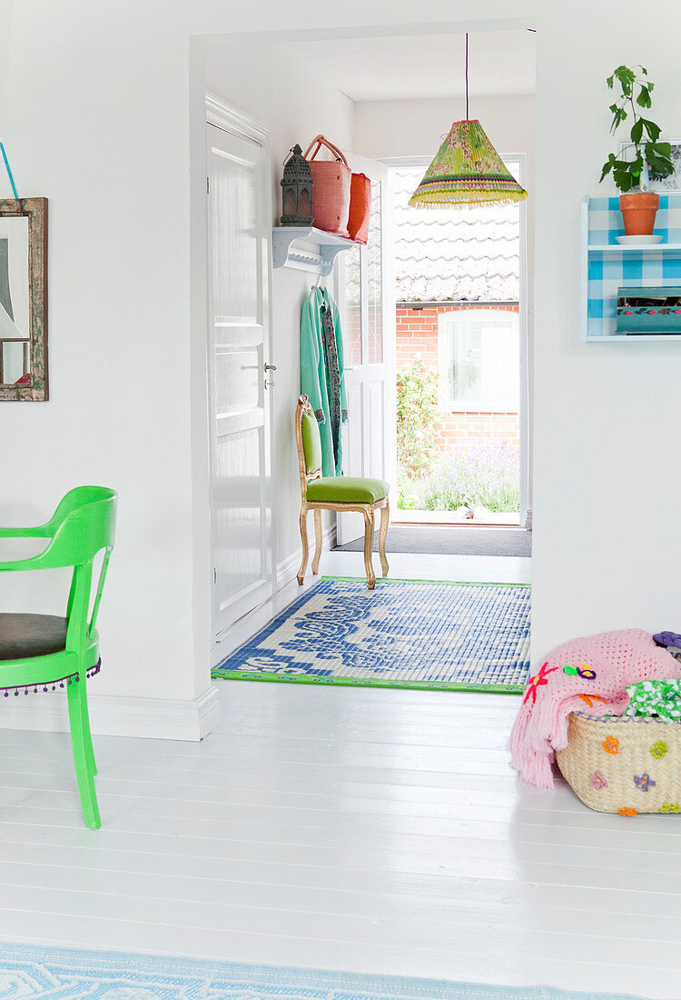 A view of a hallway with a coat rack on the wall