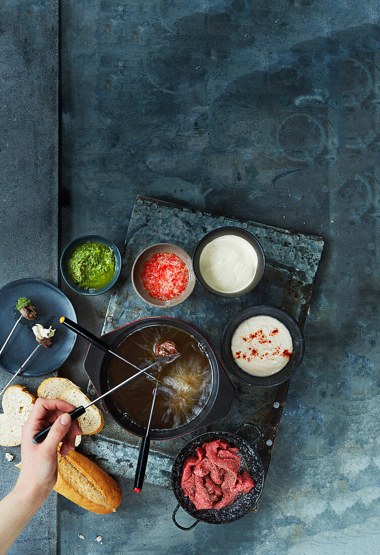 Meat fondue with beef fillet, served with various dips and a baguette