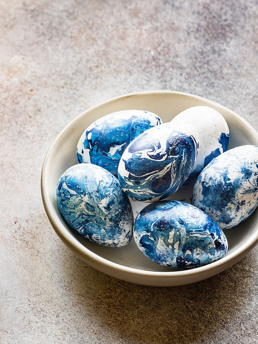 A bowl of blue marbled Easter eggs
