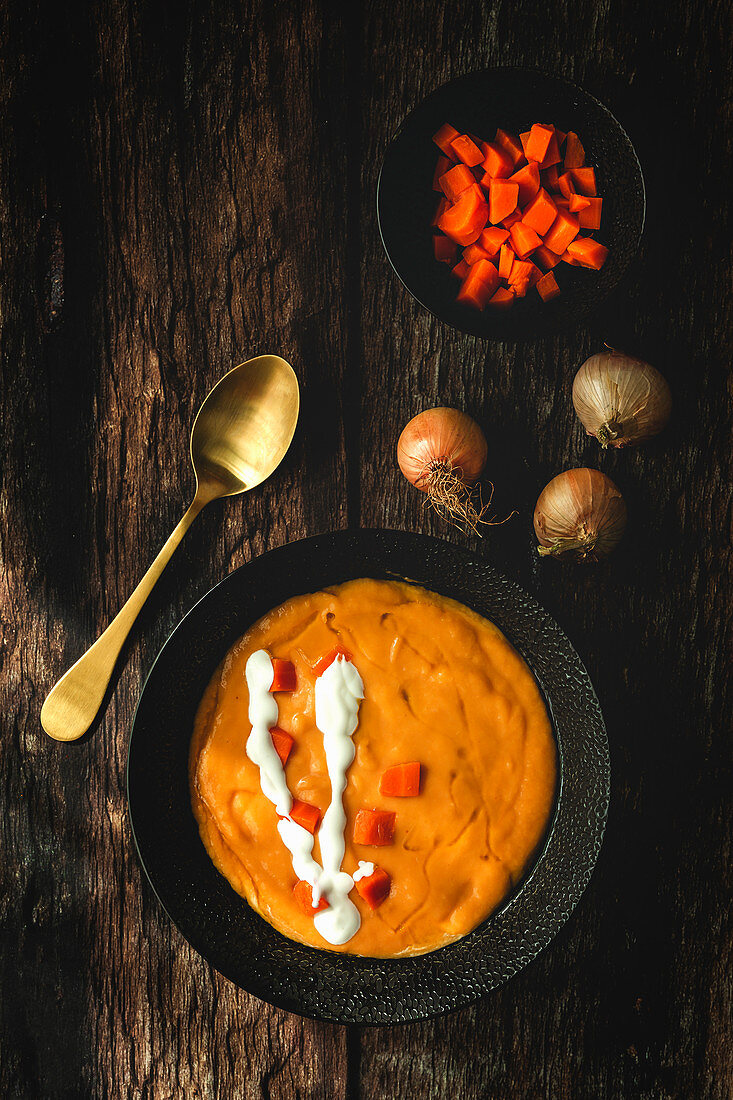 Gemüsecremesuppe mit Karottenwürfeln und Zwiebeln