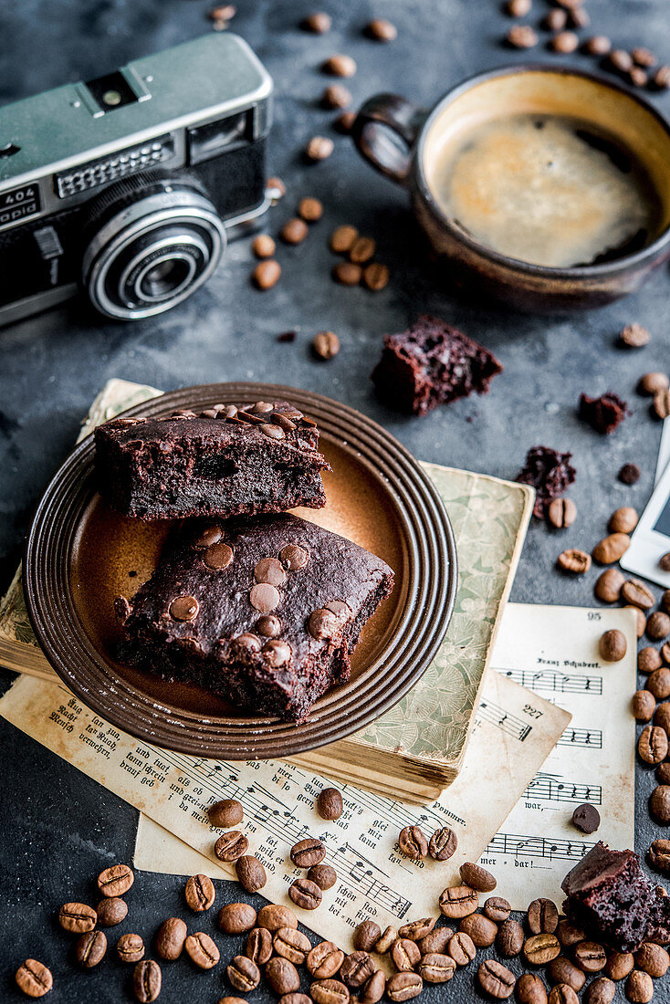 Brownies surrounded by a coffee cup, camera, coffee beans and music sheets