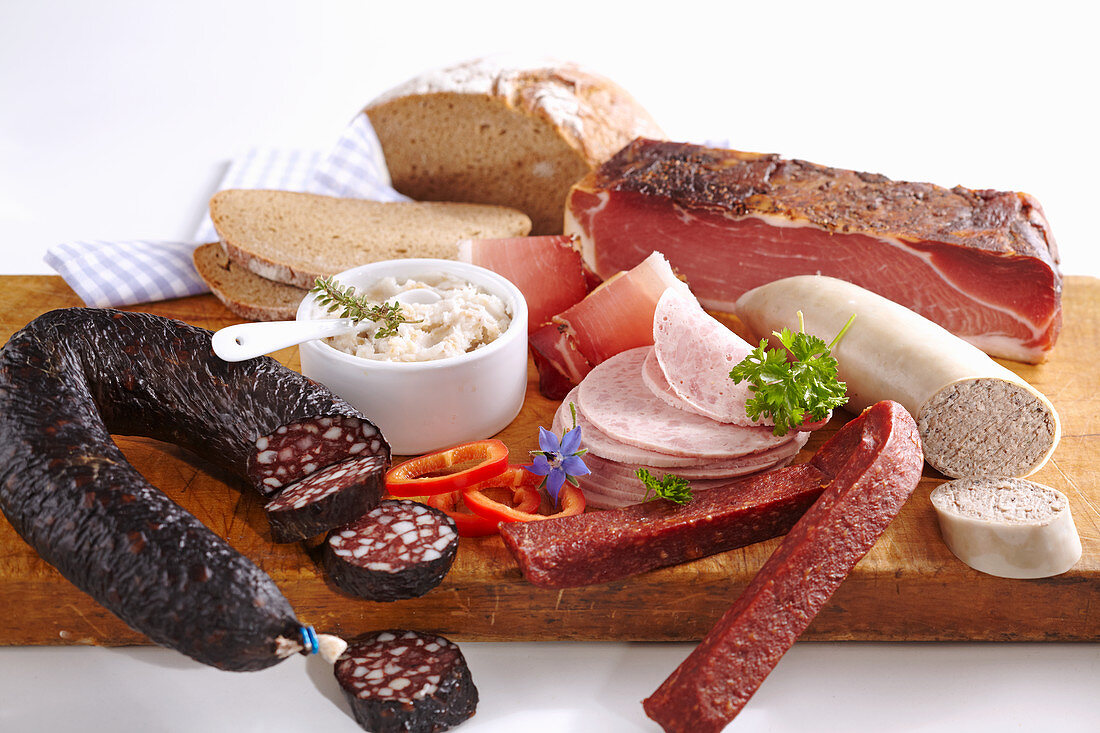 A snack platter featuring Landjäger (spicy smoked sausage), ham, liver pâté, black pudding, chasseur sausage and dripping