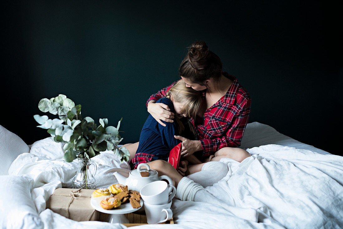 A mother and daughter having breakfast in bed