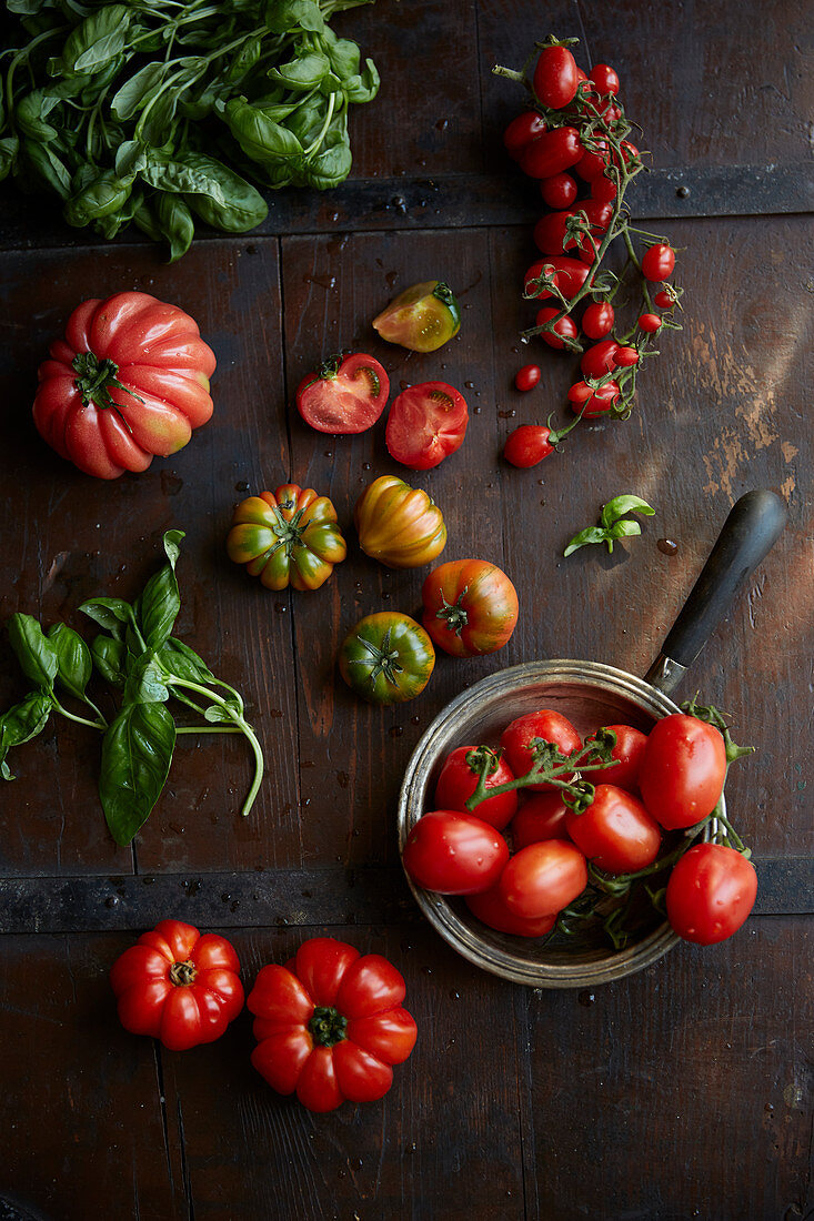 Verschiedene Tomaten auf Holzuntergrund und im Glas