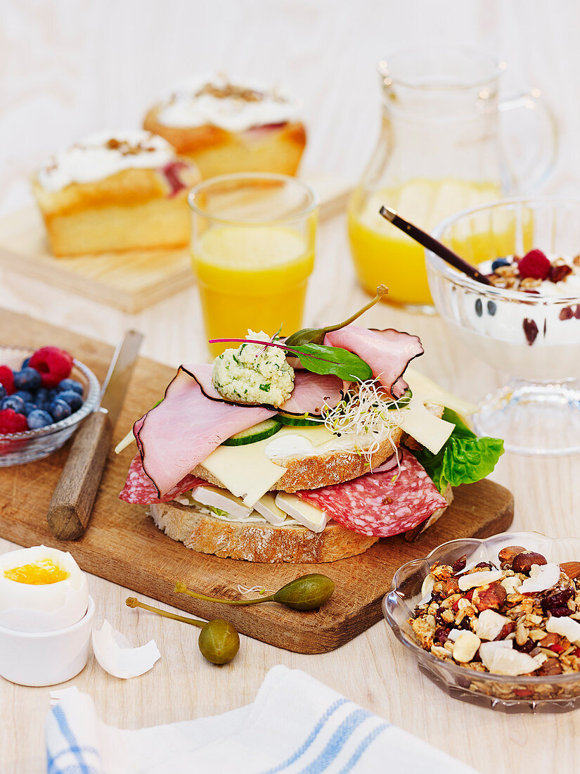 An open sandwich topped with meat and cheese on a breakfast table