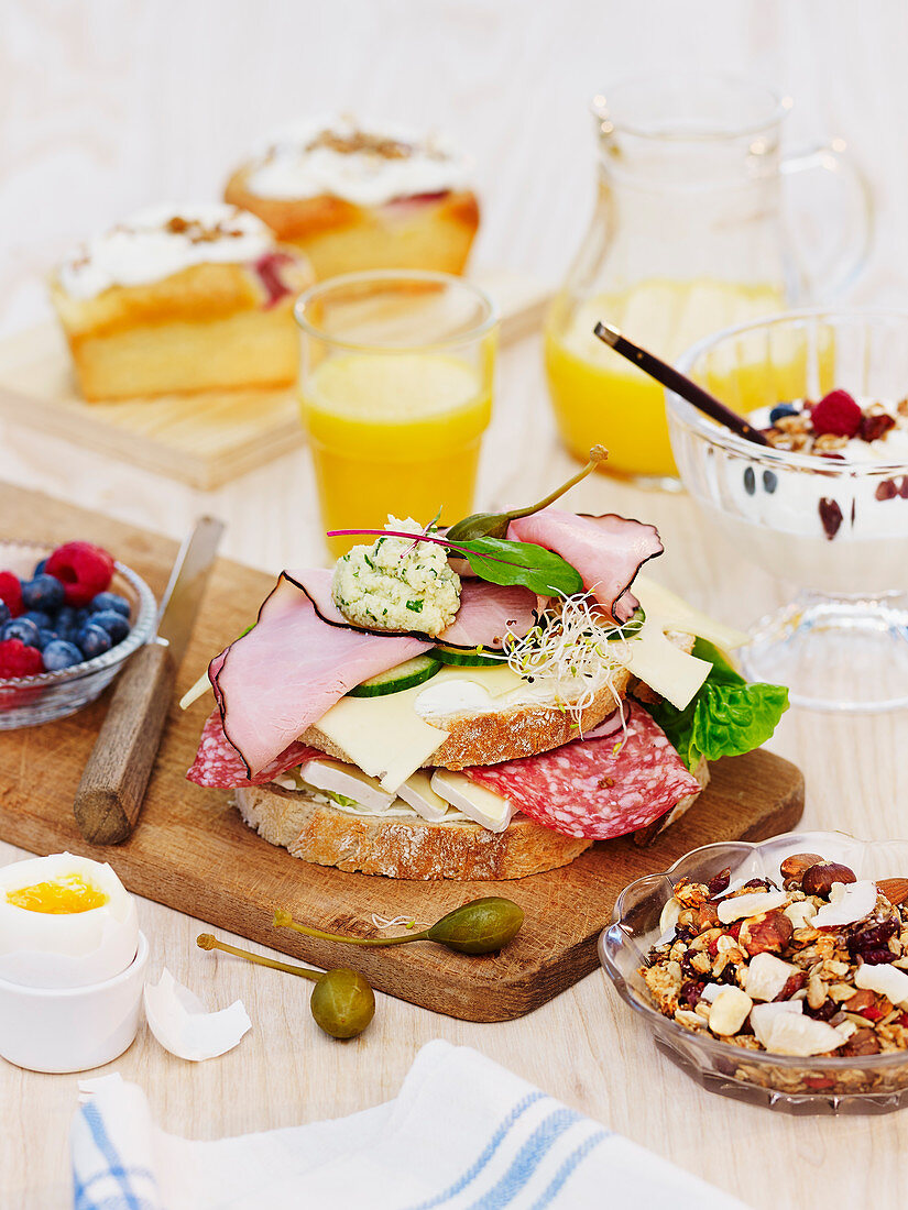 Sandwich belegt mit Wurst und Käse auf Frühstückstisch