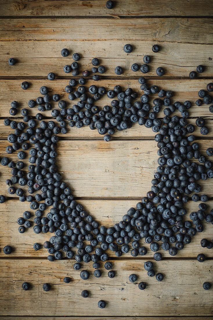 Blueberries arranged in a heart-shape on a wooden surface