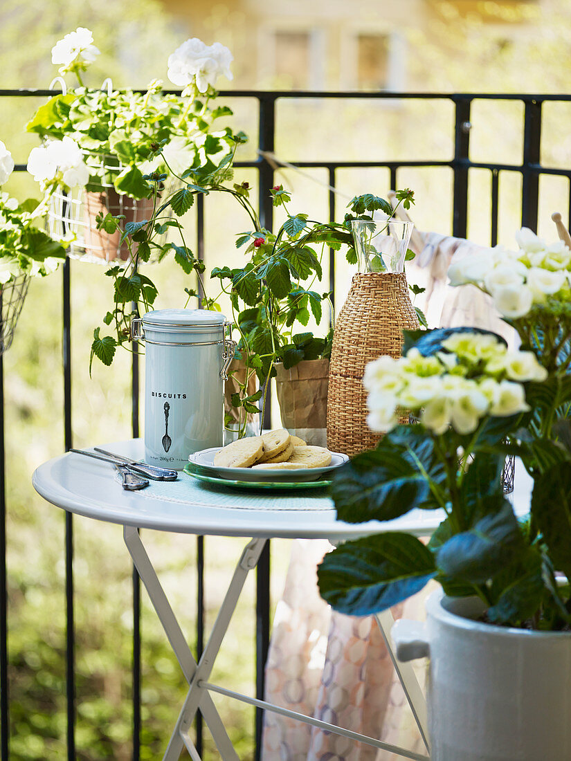 Round folding table on balcony surrounded by flowers