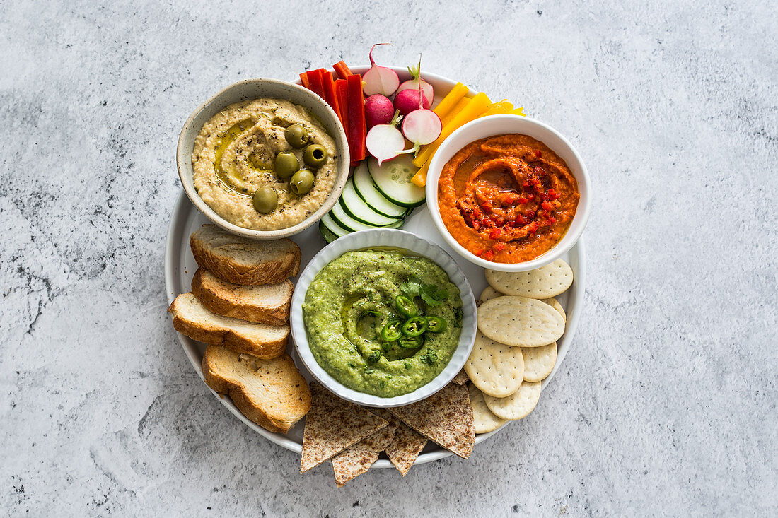 Roasted red bell peppers hummus, jalapeno, avocado and cilantro hummus, provenzal herbs and olives hummus