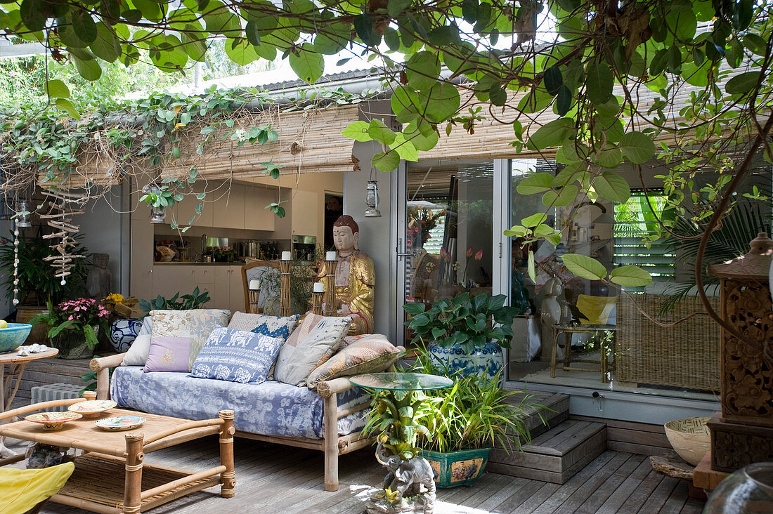 Sofa and Buddha statue on ethnic-style terrace