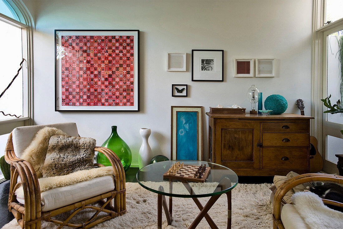 Wicker armchair, antique sideboard and coffee table with glass top in living room