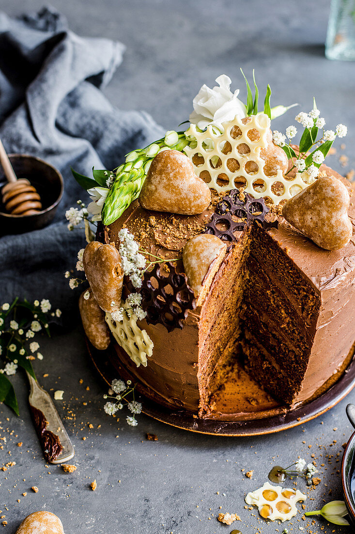 Gingerbread and honey cake decorated with gingerbread hearts and chocolate in the shape of honeycombs