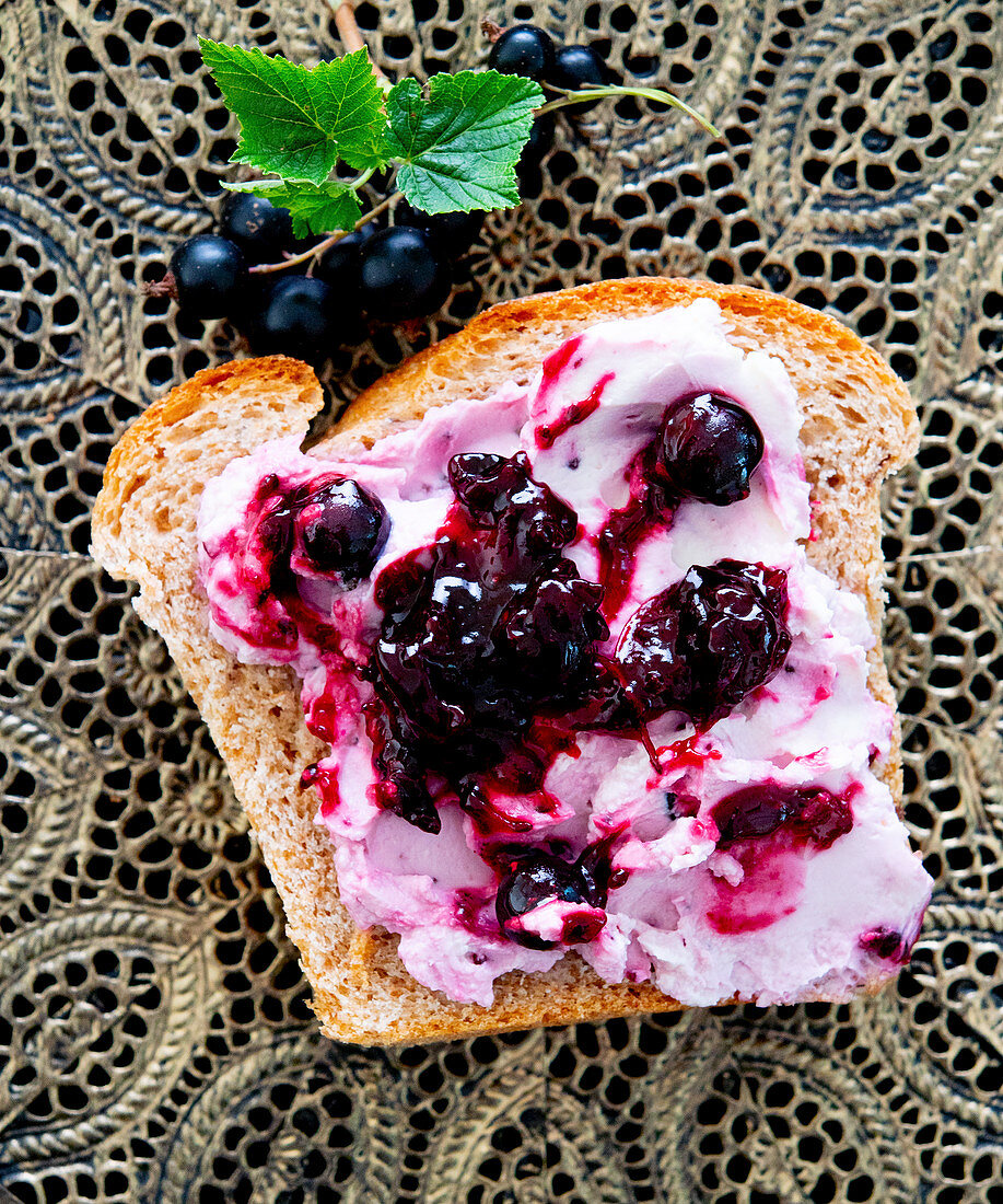 White bread with cream cheese and blackcurrants