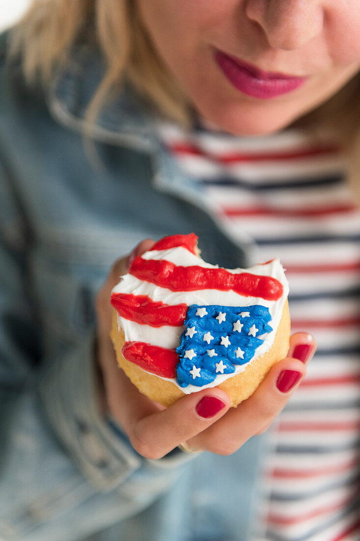 Frau hält Cupcake mit USA-Flagge