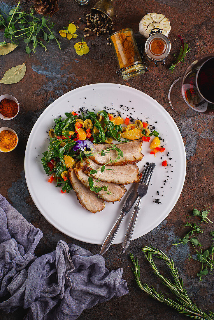 Salat mit Schweinebratenscheiben und Essblüten