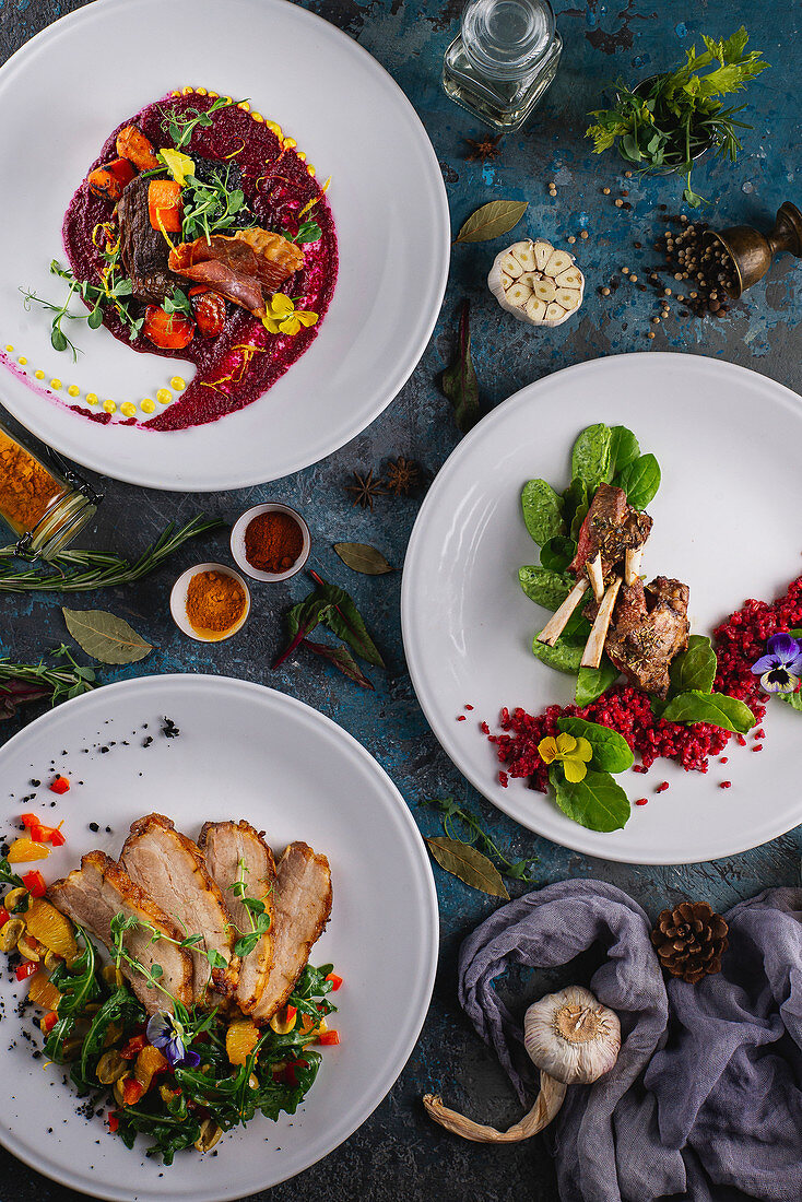 Drei verschiedene Fleischgerichte mit Salat