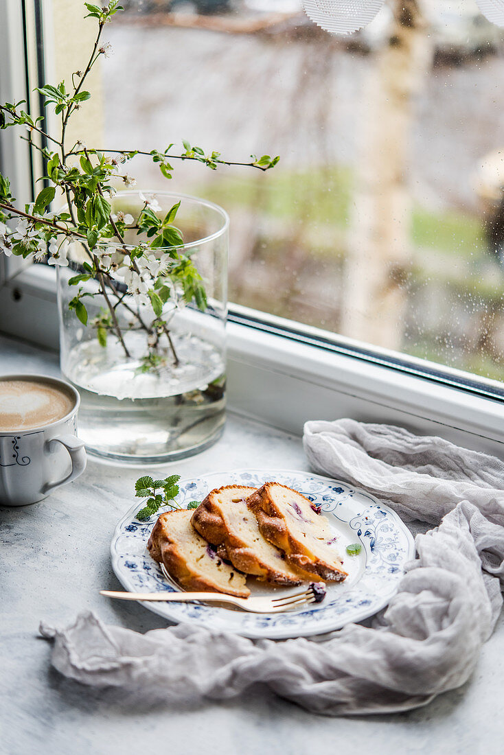 Blaubeer-Napfkuchen und Kaffee vor dem Fenster