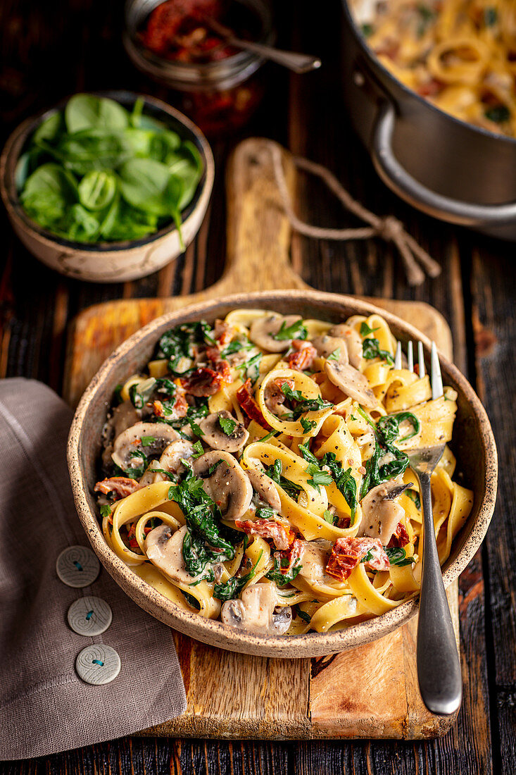 Bandnudeln mit Champignons, getrockneten Tomaten, Spinat und Käse