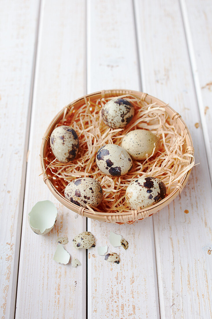 Quail eggs in a basket with straw