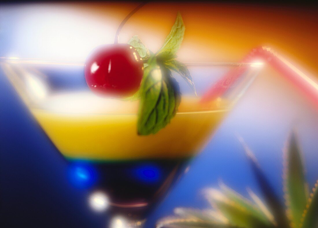 Zweifarbiger Cocktail mit Blue Curacao & Orangensaft; Kirsche