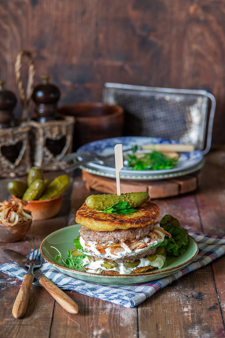 Potato fritter (draniki) burger with onion, beef and sour cream