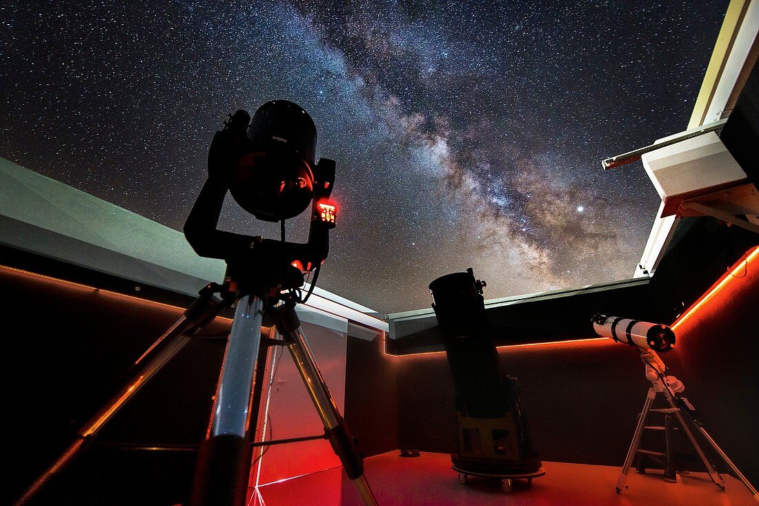 Telescopes at an observatory with the Milky Way