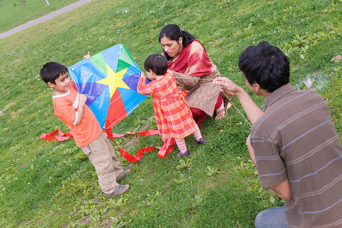 Young family in the park flying a kite