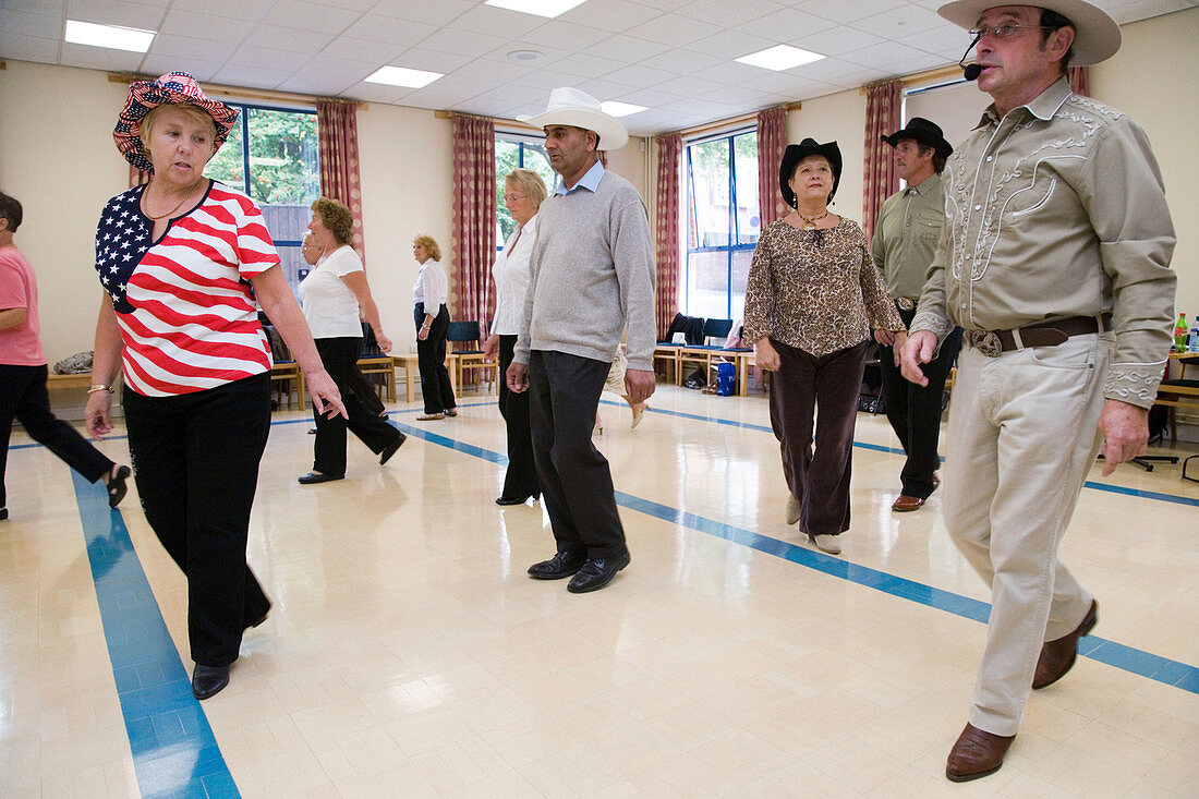 Group of older people line dancing