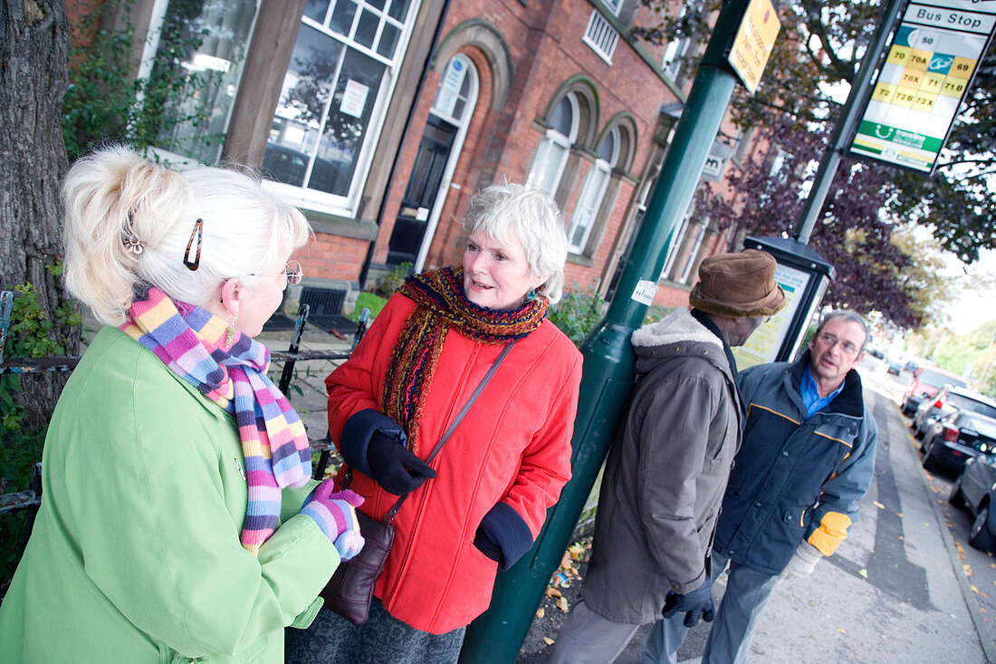 Group of older people waiting at a bus stop