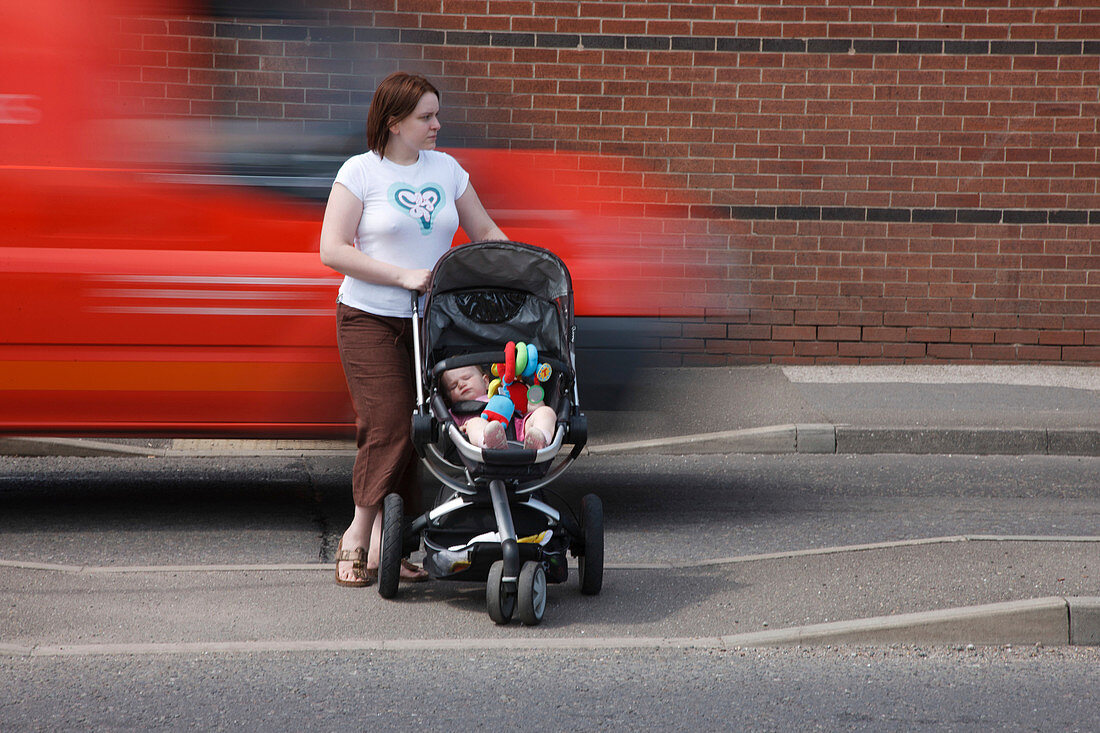 Mother trying to cross road with baby as traffic speeds by