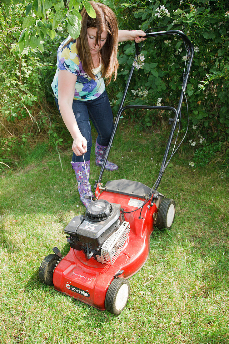 Woman starting lawnmower