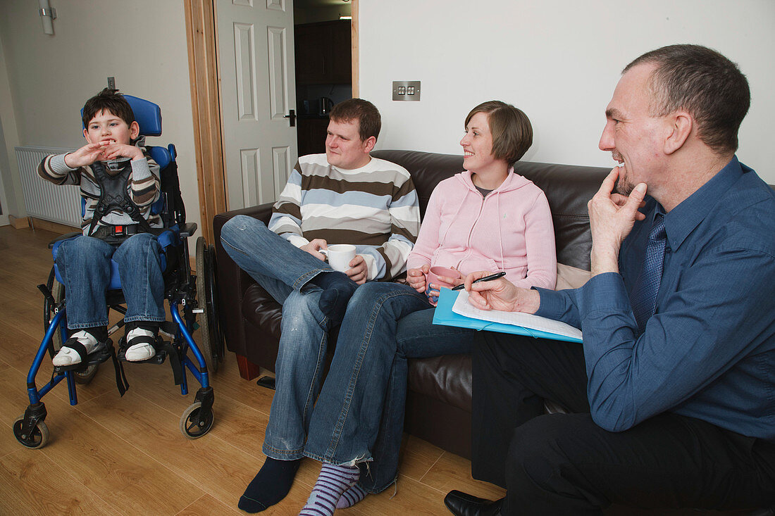 Social worker visiting boy with cytomegalovirus syndrome