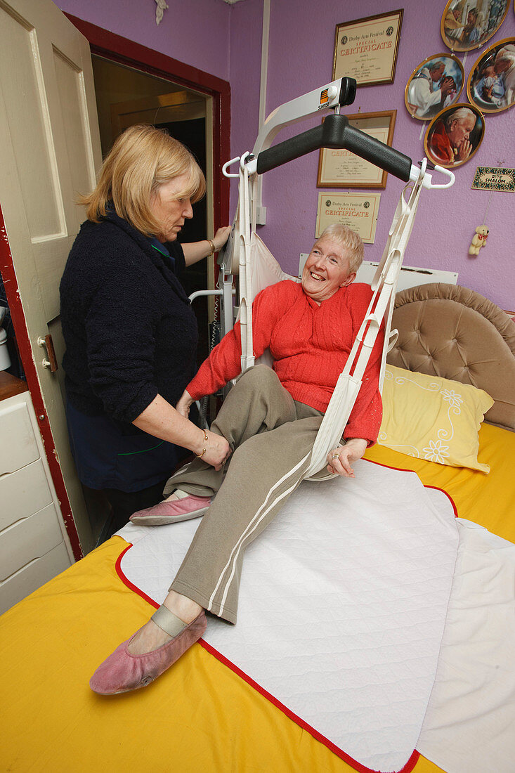 Carer with woman with disability using a hoist