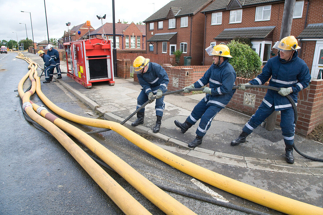 Members of the fire rescue service moving high volume pumps