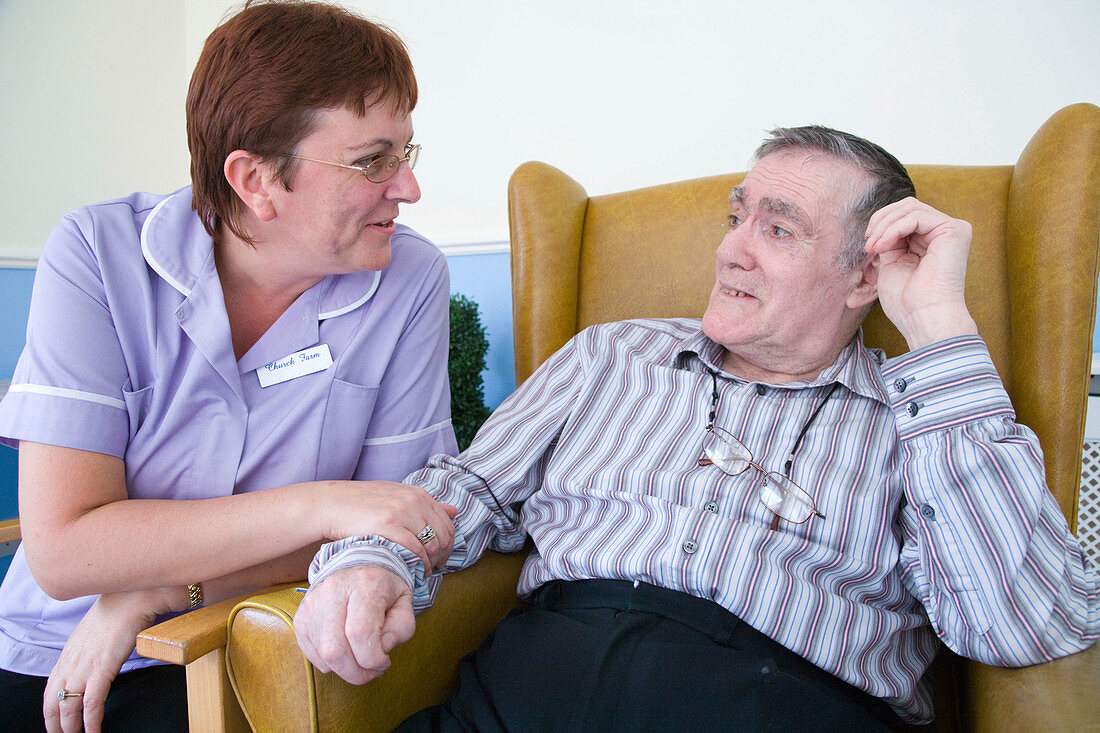 Care Assistant chatting to man with Alzheimer's Disease
