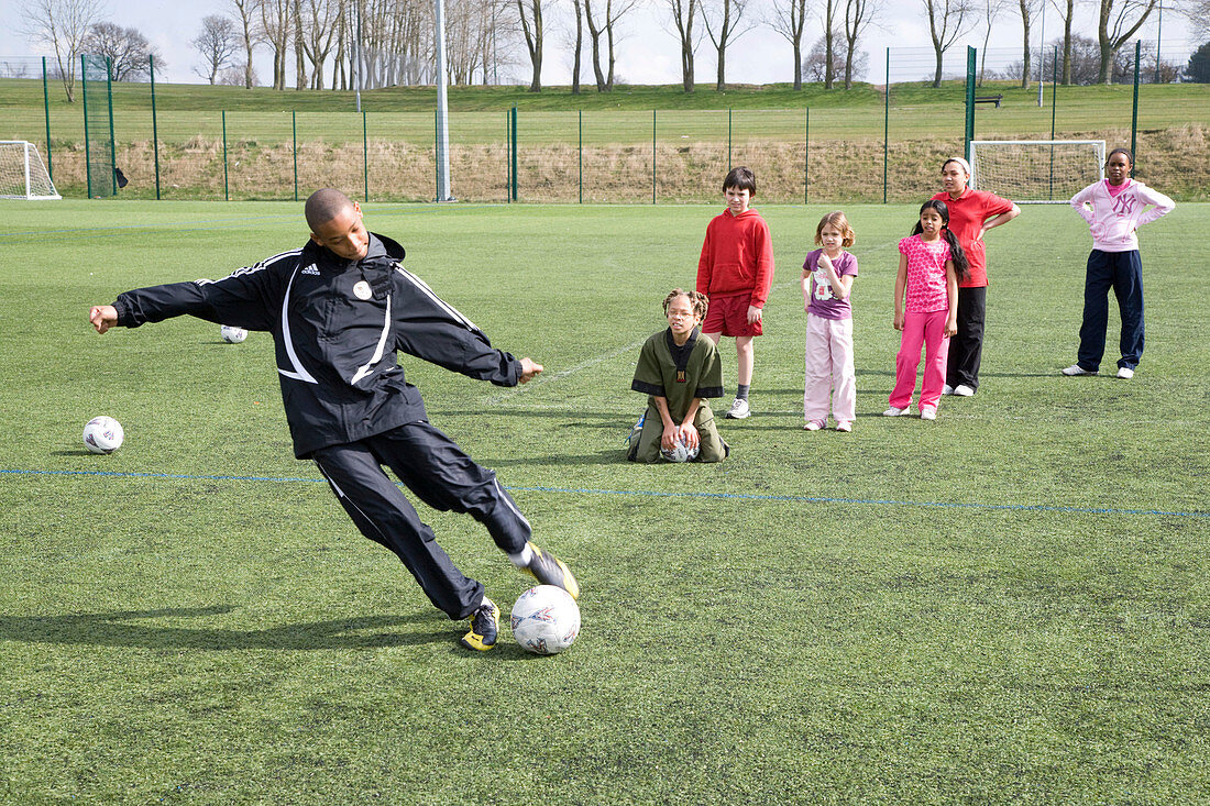 Group of children practicing dribbling a football