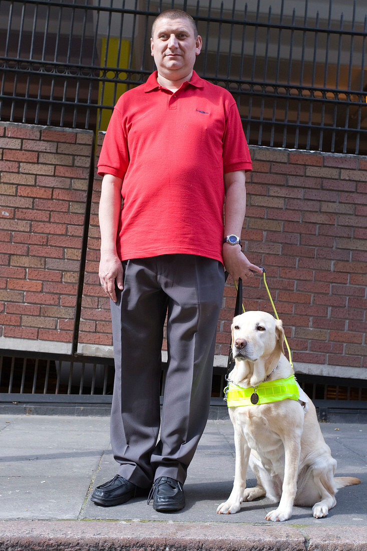 Vision impaired man with his guide dog