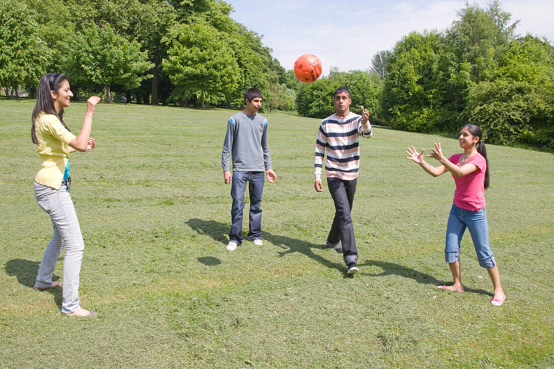 Group of friends playing with a ball in the park