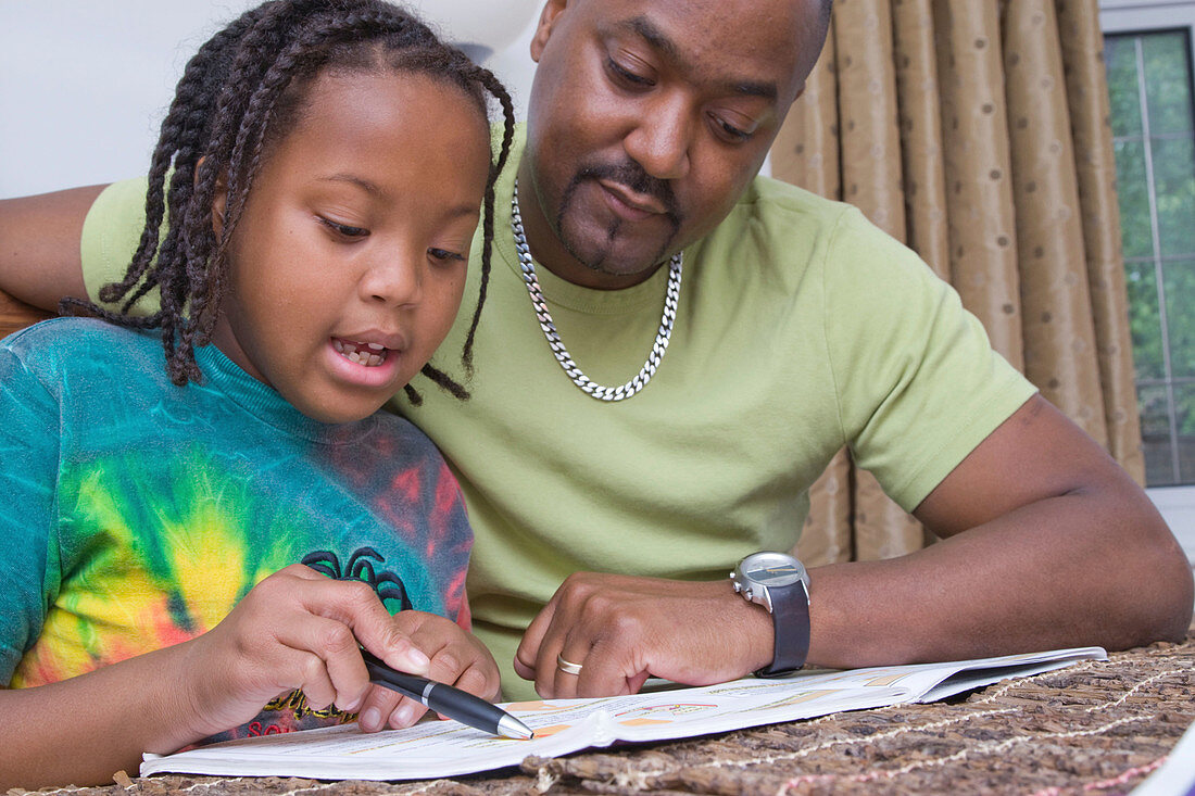 Father helping his young daughter with her homework