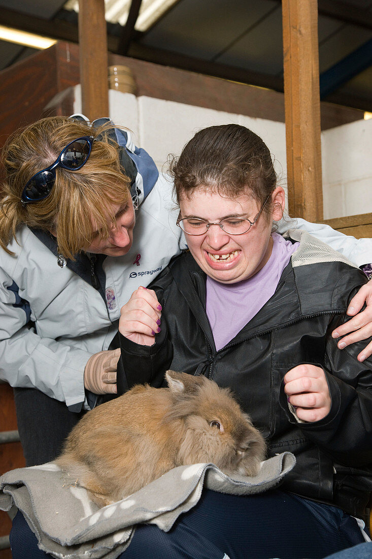 Young woman with learning disabilities with a large rabbit