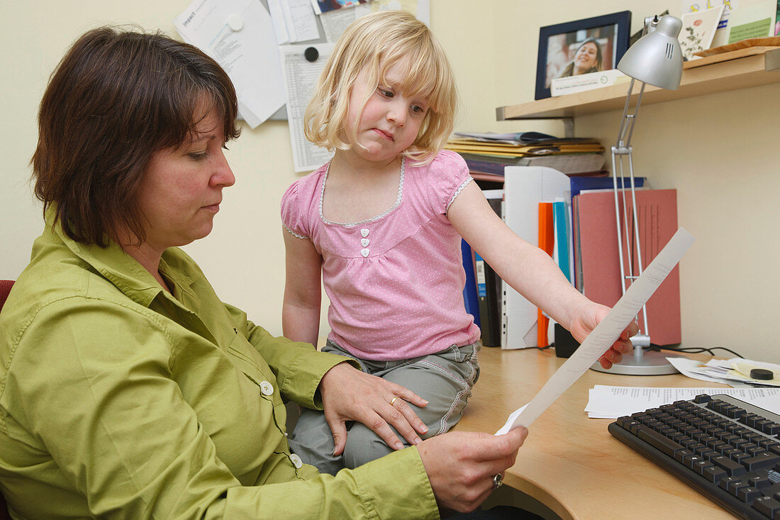 Mother in office trying to work being disturbed by daughter