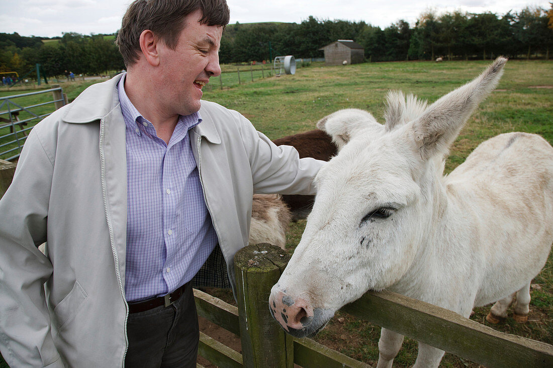 Man with learning disability on trip to farm with donkey
