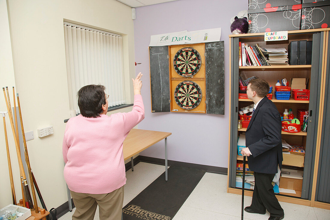 Woman with scoliosis playing darts