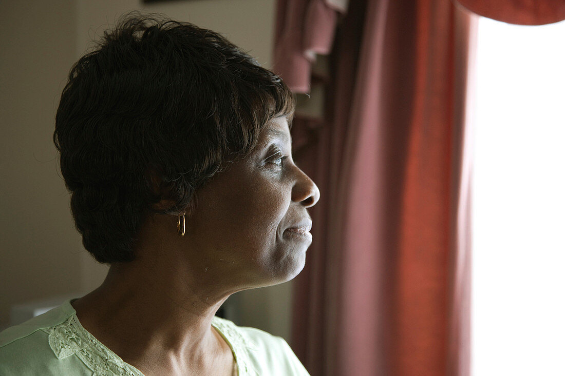Portrait of an older woman looking out of a window