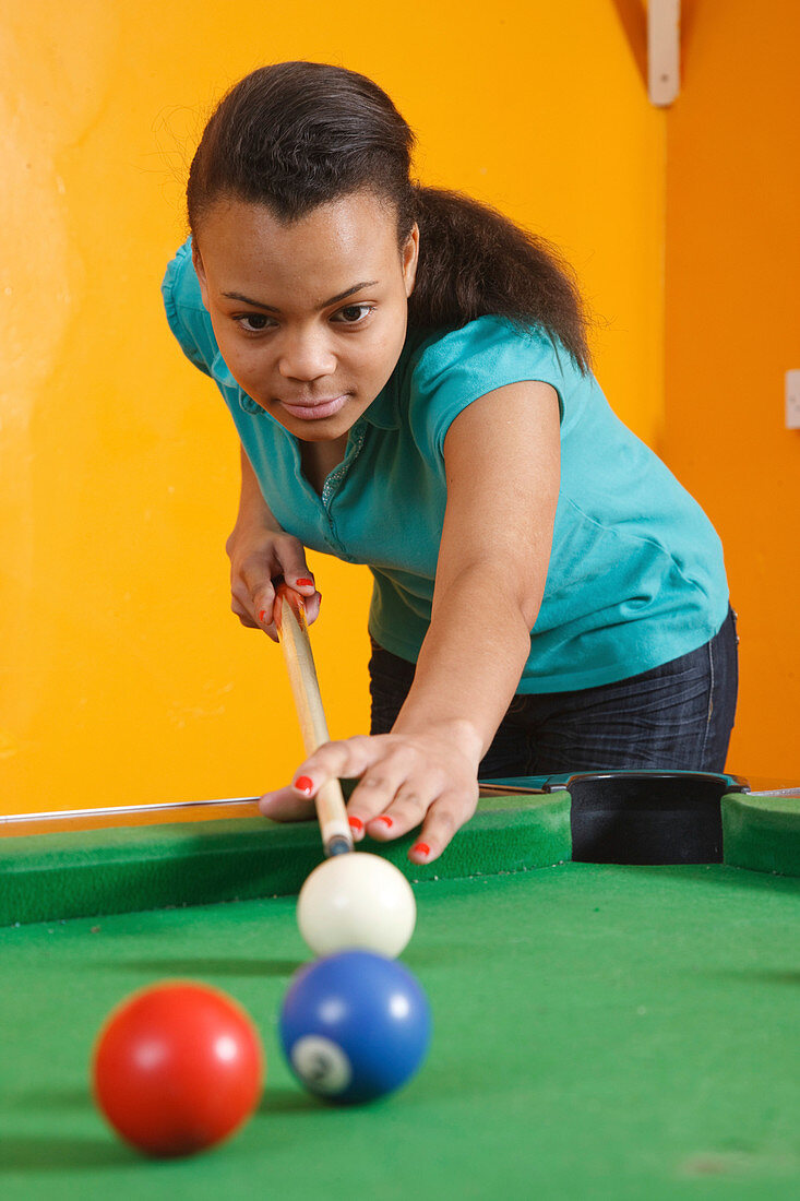 Girl playing pool in youth club
