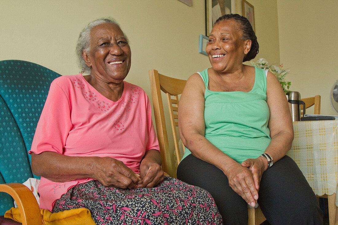 Carer and elderly visually impaired woman laughing