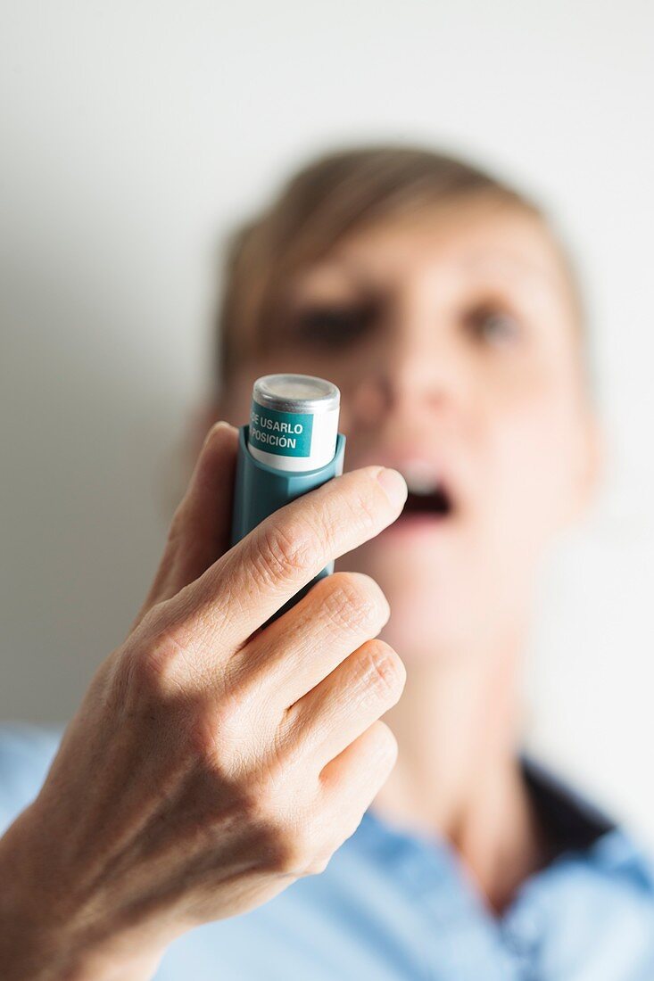 Close-up of woman using an asthma inhaler