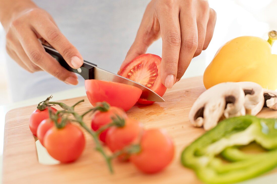 Woman chopping fresh tomatoes