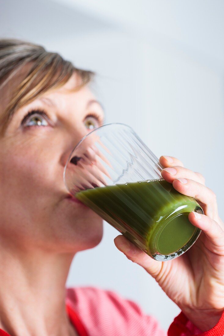 Woman drinking a green juice