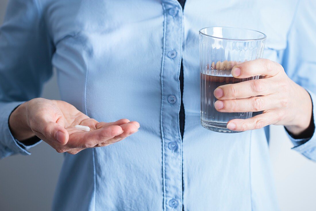 Woman taking medication with a glass of water
